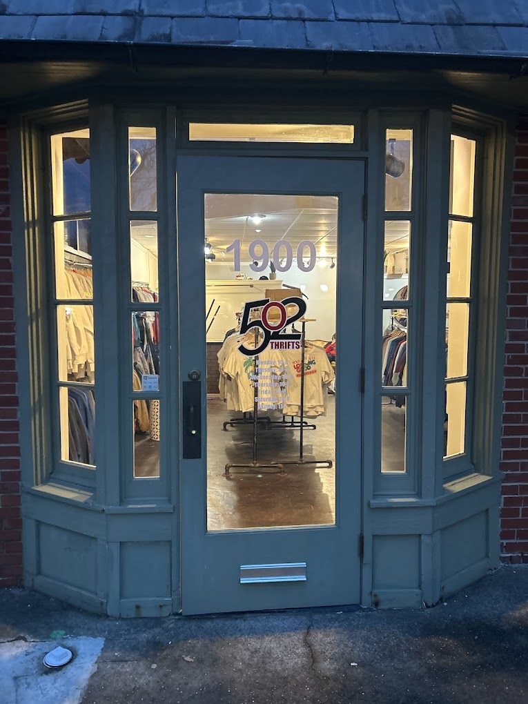 502 Thrifts storefront at night, warm glow through bay windows